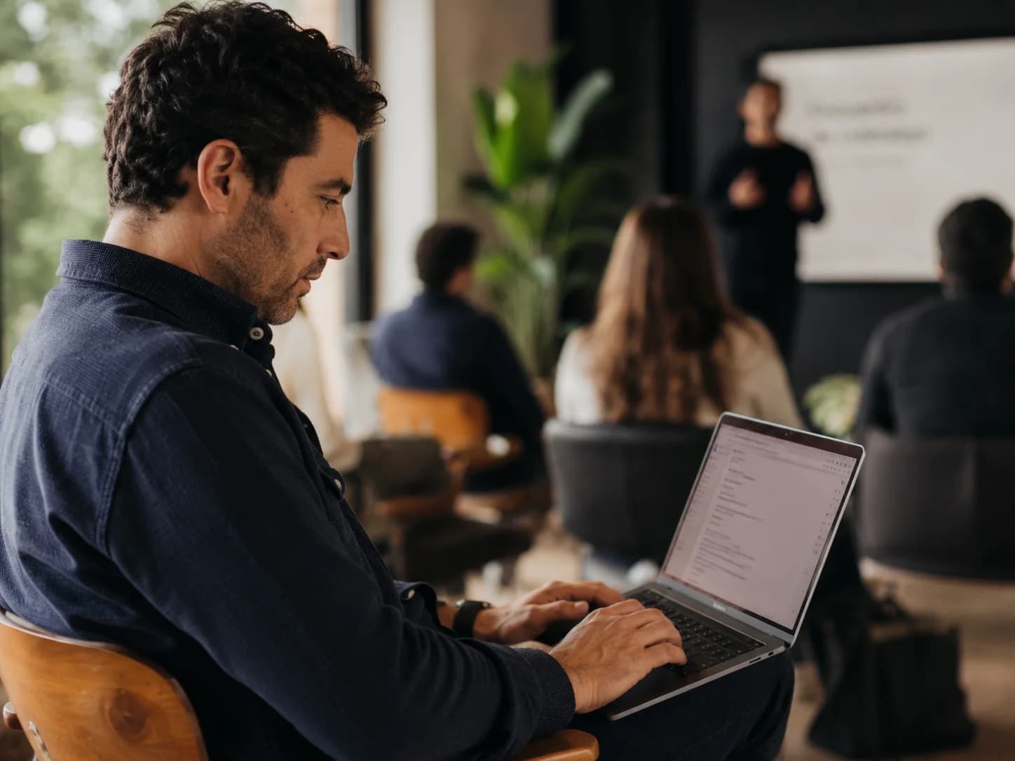 Attendee taking notes on a laptop during a training session