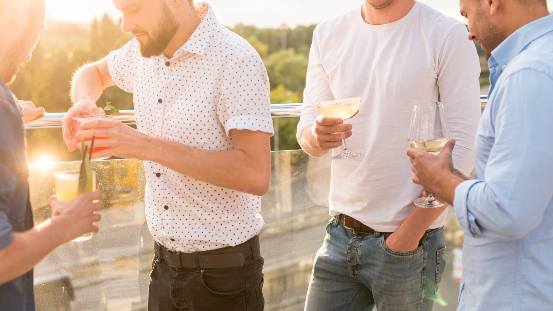 Equipo de una empresa celebrando con una copa en una terraza al atardecer