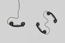 Dos auriculares de teléfono antiguos con el cable enredado